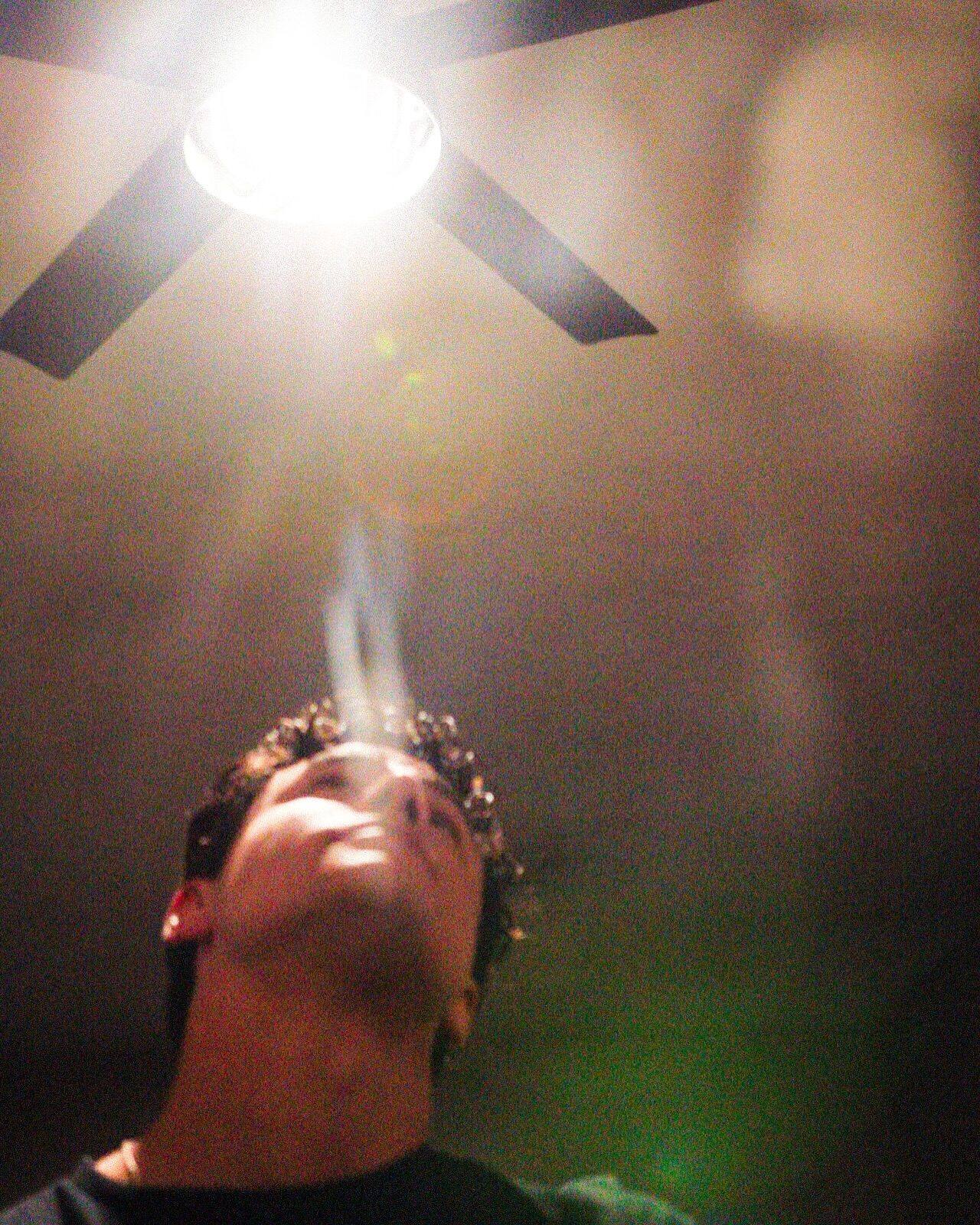 Looking straight up at a ceiling fan and a bare bulb