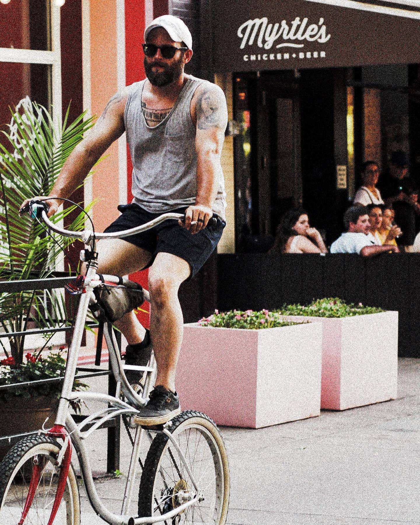 A rider on a tall bicycle outside Myrtle's Chicken