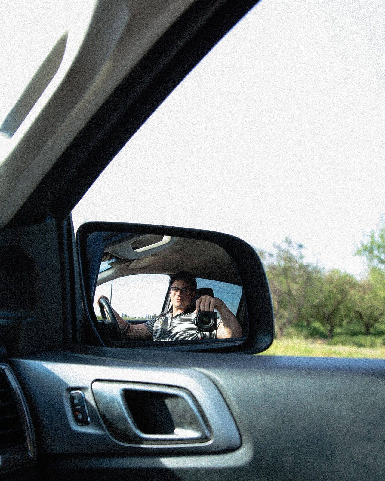 A reflection in a car wing mirror, camera raised