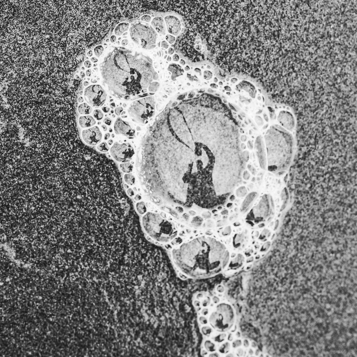 Sea foam on wet sand, close up